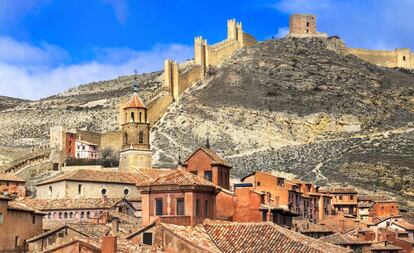 Encanto medieval, entramados de madera y tabicones de yeso rojizo, preciosas balconadas corridas, poco más de 1.000 habitantes, y habitual en los primeros puestos de los rankings de los pueblos más bonitos (elegido también como <a href="https://elviajero.elpais.com/elviajero/2018/11/15/actualidad/1542273758_657958.html" target="_blank">el más bonito de España por los lectores de EL PAÍS</a>). Es difícil hablar de Albarracín, ubicado sobre una colina de los Montes Universales, en el istmo y la península que forma el río Guadalaviar, sin que suene a descripción trillada. Es un prodigio de adaptación a la complicada orografía del terreno, con calles estrechas, jalonadas de escalinatas y pasadizos, y casas de muros irregulares con aleros que se tocan. Se pueden destacar edificios como la catedral del Salvador o el alcázar, pero, en realidad, todo el conjunto histórico de este pueblo de la provincia de Teruel es un monumento en sí mismo.<br></br> Más información: <a href="https://www.albarracin.es/" target="_blank">albarracin.es</a>