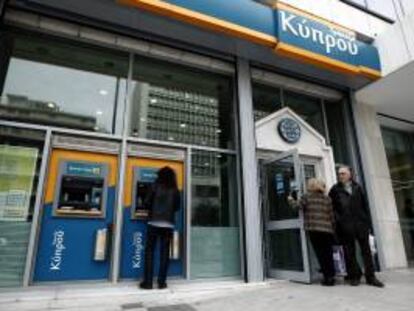 Un hombre retira dinero de un cajero automático de una sucursal del Banco de Chipre en Atenas (Grecia).