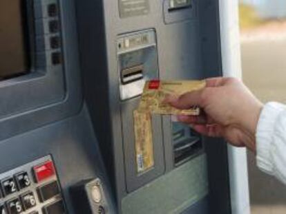 Una mujer saca dinero de un cajero automático. EFE/Archivo