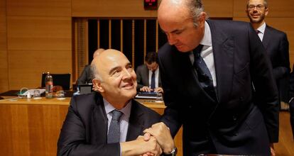 El ministro de Econom&iacute;a espa&ntilde;ol, Luis de Guindos, saluda al comisario europeo de Asuntos Econ&oacute;micos y Financieros, Pierre Moscovici.