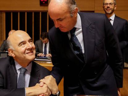 El ministro de Econom&iacute;a espa&ntilde;ol, Luis de Guindos, saluda al comisario europeo de Asuntos Econ&oacute;micos y Financieros, Pierre Moscovici.