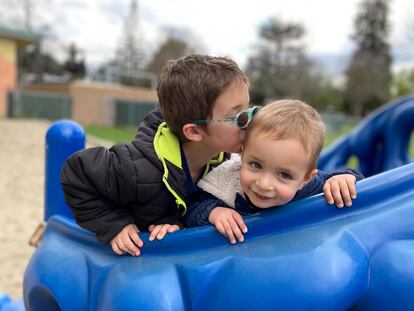 Dos niños juegan en un parque infantil.