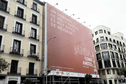 Una lona publicitaria tapa la fachada de un edificio en la Plaza del Cascorro, en La Latina