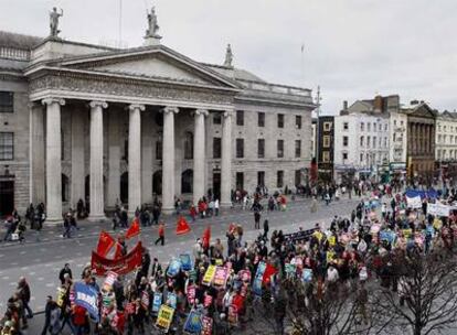 Cien mil personas, según la Policía, han marchado esta tarde por las calles del centro de Dublín para protestar contra las medidas que está adoptando el Ejecutivo irlandés ante la crisis. En la imagen, la protesta a su paso por el emblemático edificio de Correos de la capital irlandesa.