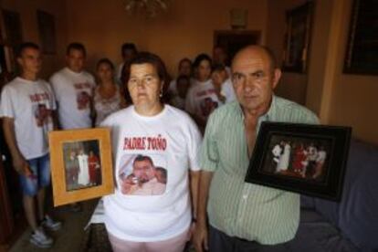 Los padres del padre Toño muestran fotos de su hijo. Detrás el resto de familia.