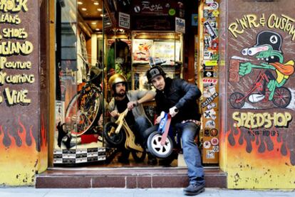 Juan Ibáñez (izquierda) y Damián Mollá, montados en unas pequeñas bicis en la tienda Chopper Monster.