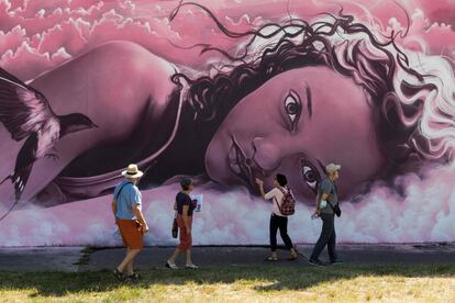 Un grupo de turistas miran un grafiti mientras visitan Street Art City en Lurcy-Levis (Francia).