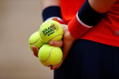 Un recogepelotas sostiene tres de las nuevas bolas Wilson.