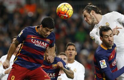 El delantero Gal&eacute;s del Real Madrid Gareth Bale salta por el bal&oacute;n con el uruguayo Luis Su&aacute;rez, del FC Barcelona, durante el partido de Liga de Primera Divisi&oacute;n, de la jornada 12&ordm;, que les enfrenta esta tarde en el Estadio Santiago Bernab&eacute;u, en Madrid.