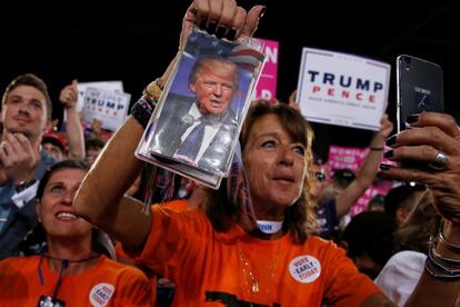 Votantes de Donald Trump muestran imágenes del candidato republicano en Tampa, Florida (EE UU) el 24 de octubre.