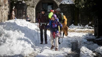Peregrinos de origen asiático llegan a O Cebreiro cubierto de nieve.