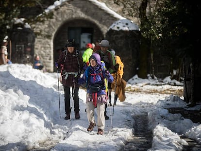 Peregrinos de origen asiático llegan a O Cebreiro cubierto de nieve.