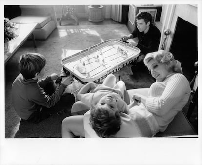 John Cassavetes juega un partido de hockey de mesa con su hijo, Nick, mientras su esposa, Gena Rowlands, juega con una  niña, en el set de la película 'Husbands (Maridos)', en 1970. 