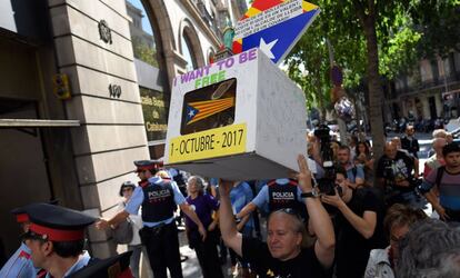 Un hombre sostiene una urna de cartón con una estelada frente al Tribunal Superior de Justicia de Barcelona.