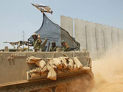 Soldados israelíes patrullan junto al muro que el Gobierno de Tel Aviv está construyendo para separar Cisjordania de Israel.