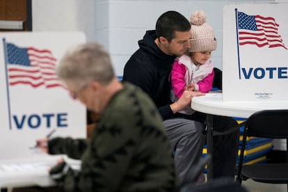 Dustin Ritchie vota acompañado de su hija en el colegio electoral de Superior, Wisconsin, este martes.