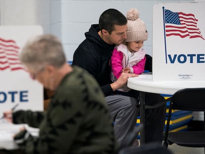 Dustin Ritchie vota acompañado de su hija en el colegio electoral de Superior, Wisconsin, este martes.