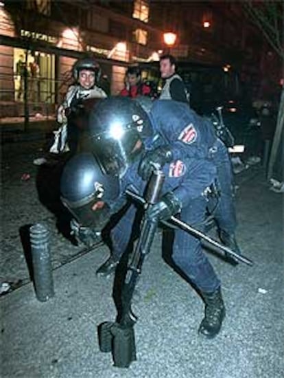 Dos agentes del Cuerpo Nacional de Policía en acción ante los disturbios provocados por un grupo de violentos.