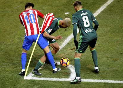 El centrocampista del Betis Daniel Ceballos y el centrocampista belga del Atlético de Madrid Yannick Ferreira-Carrasco, luchan por el balón ante el centrocampista francés del Betis Jonas Martín.