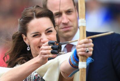 Kate Middleton, duquesa de Cambridge, dispara una flecha en una demostración de tiro con arco en Paro, Bután, el 14 de abril de 2016, mientras su marido, el príncipe Guillermo, la observa. 