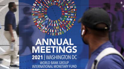 Um homem passa por um cartaz das reuniões anuais do Grupo do Banco Mundial e do Fundo Monetário Internacional, nesta segunda-feira, em Washington.