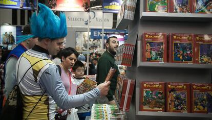 Un 'otaku', ataviado como un personaje de 'Dragon Ball', contempla un volumen de esta serie japonesa en el Salón del Manga.