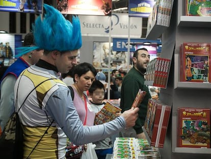 Un 'otaku', vestit de personatge de 'Dragon Ball', contempla un volum d'aquesta sèrie japonesa al Saló del Manga.