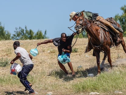 Un agente fronterizo de EE UU agarra a un migrante haitiano cerca del campamento de Del Río, Texas, este domingo.