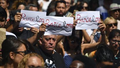 Tres personas portan el dise&ntilde;o creado por Amat en la concentraci&oacute;n de personas tras el atentado de La Rambla. 