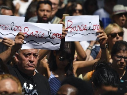 Tres personas portan el dise&ntilde;o creado por Amat en la concentraci&oacute;n de personas tras el atentado de La Rambla. 