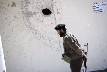 Un rebelde libio es fotografiado junto a un impacto de proyectil en una pared en Ajdabiya (Libia), el 10 de abril de 2011.
