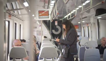 Una interventora controla si els passatgers viatgen amb bitllet en un tren de Rodalies.