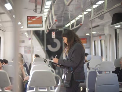 Una interventora controla si els passatgers viatgen amb bitllet en un tren de Rodalies.