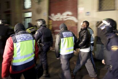 La policía custodia a uno de los detenidos en la operación en Barcelona contra el terrorismo islamista.