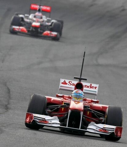 El piloto español de la escudería Ferrari Fernando Alonso seguido por el británico Jenson Button (McLaren) durante los entrenamientos de pretemporada de Fórmula Uno en el Circuito de Jerez de la Frontera.