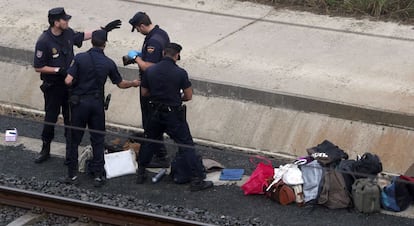 Agentes de la policía buscan documentos para poder reconocer a las víctimas del accidente que continúan sin ser identificadas, 25 de julio de 2013.