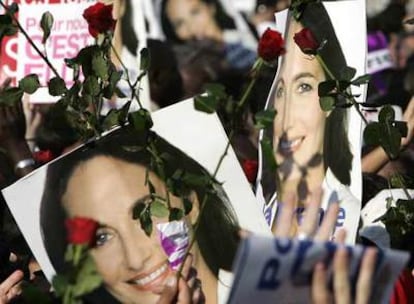 Asistentes al mitin de Ségolène Royal en París sostienen rosas y carteles de la candidata socialista.