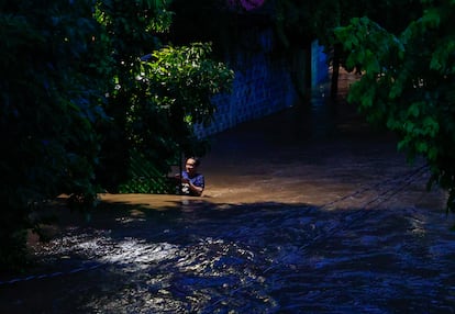 Las lluvias han generado incrementos en ríos o arroyos, por lo que se recomienda a las personas cercanas a un curso de agua vigilar el nivel del caudal. En la imagen, un hombre camina entre una vereda inundada, en Técpan de Galeana.
