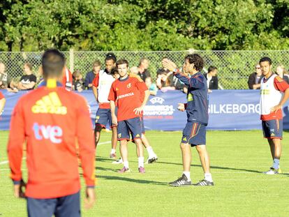 Mata (en el centro) escucha con sus compañeros las instrucciones de Luis Milla, el técnico.