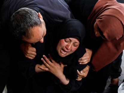 Una mujer llora junto a los cuerpos sin vida de unos palestinos asesinados por un bombardeo israelí en Rafah este martes.