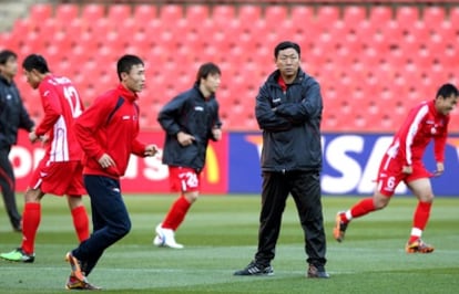 Los futbolistas y el entrenador de Corea del Norte durante un entremiento.
