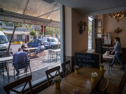 Una camarera sirve a los clientes de una terraza en Sevilla, durante el primer día de la fase 1 de la desescalada.