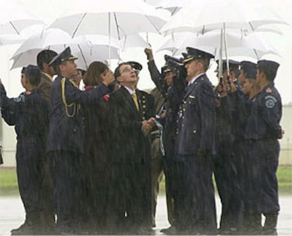 El presidente Álvaro Uribe condecora a varios oficiales, bajo un chaparrón, el viernes en una base de Bogotá.