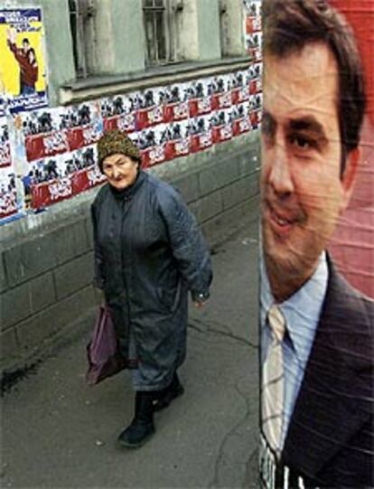 Una mujer pasa junto a un cartel de Saakashvili, ayer en Tbilisi.
/ REUTERS