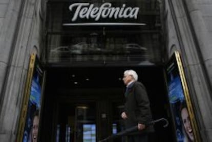 Una persona pasea ante la tienda de Telef&oacute;nica en Gran V&iacute;a, en Madrid.