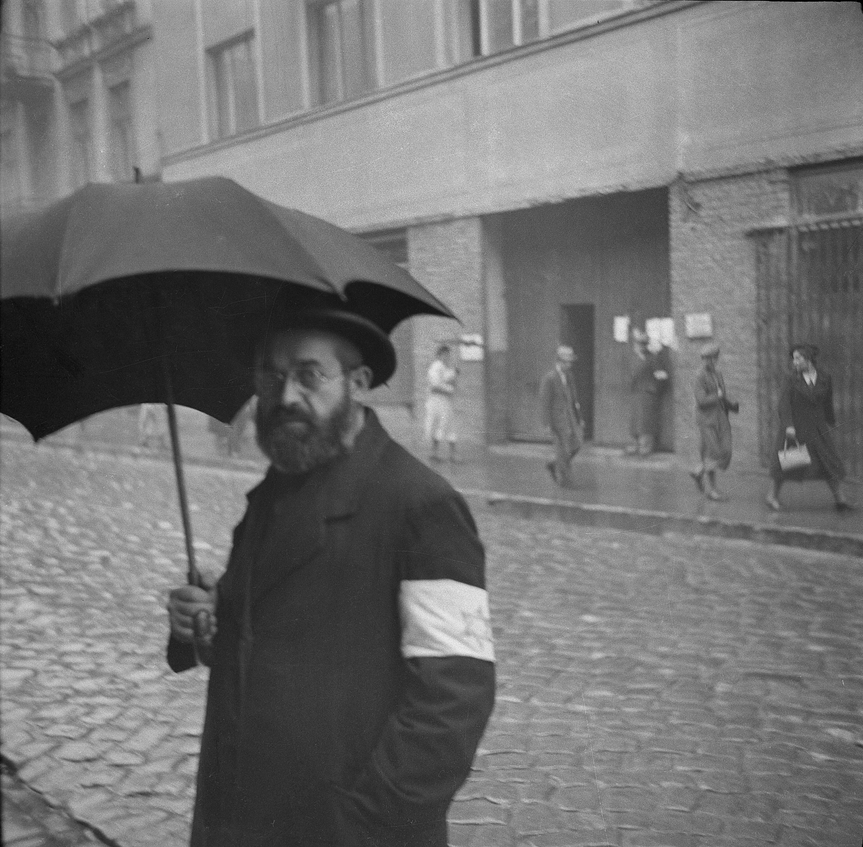 Un ciudadano judío con el brazalete de la estrella de David mira fijamente a la cámara al ser retratado durante la ocupación nazi de la ciudad de Oświęcim