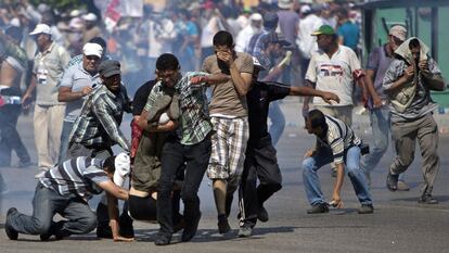 Partidarios de los Hermanos Musulmanes intentan trasladar a uno de les heridos durante el tiroteo entre los partidarios de Morsi y el ejército egipcio en el exterior de la sede de la Guardia Republicana en El Cairo (Egipto), 5 de julio de 2013.