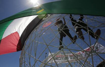 Marcha en apoyo al pueblo palestino en Quito, Ecuador. En la imagen, participantes en la protesta cuelgan una bandera palestina en la escultura El Arbolito en un parque de la capital ecuatoriana. 24 de julio de 2014.