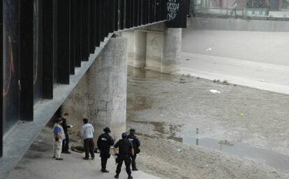 Agentes mexicanos examinan el cuerpo de Hernández junto al puente del Paso Del Norte en 2010.