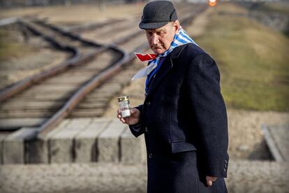 Un superviviente camina con una vela por el campo de concentración de Auschwitz.